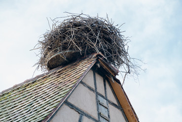 large stork nest on the roof gable of a traditional wooden half-timbered house in the Alsace region of France © makasana photo
