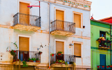 Fototapeta na wymiar Windows and balconies of residential house complex in Sardinia reflex