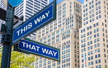 This way, that way crossroads street sign. Highrise buildings background,