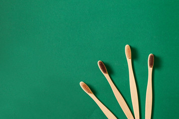 Top view or flat lay concept with eco bamboo tree toothbrushes on green background. Concept of zero...