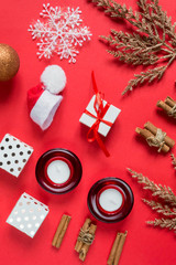 Christmas flat lay. Frame of golden Fir branches decorated with festive balls and Christmas decor on a red mocap background with copy space, christmas background