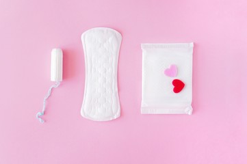 Sanitary tampon and pads on a pink background. An alternative choice of feminine hygiene products. Menstrual mothly cycle, means of protection. Top view, flat lay, copy space for text.