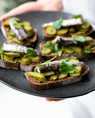 Sandwich with sardines, pickles, pesto and greens
