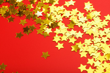 A scattering of Golden stars on red background. The concept of greeting cards, headlines and web site.