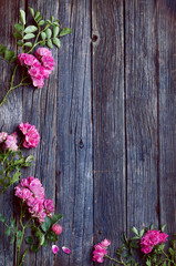 Fototapeta na wymiar wooden rustic old table texture with foliage frame and pink flowers