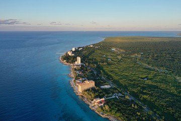 Coast line of Cozumel island with beach front hotels, tropical forest and turquoise blue Caribbean Sea