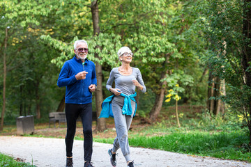 Fototapeta premium Mature couple man and woman jogging in the park