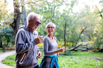 Mature couple man and woman jogging in the park