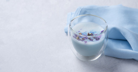 blue matcha tea in a clear glass on a white table