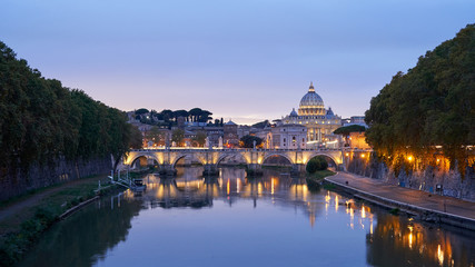 Obraz na płótnie Canvas St. Angelo bridge over the Tiber river and St. Peter's Dome in Rome at sunset, Italy.