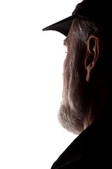 Old man in peaked cap, side view - dark close-up silhouette