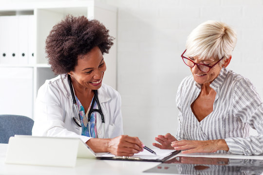 Looking at results of treatment mature woman in ambulance with her doctor
