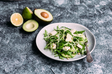 Vegetarian salad with arugula, fresh cucumber and avocado