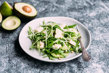 Vegetarian salad with arugula, fresh cucumber and avocado