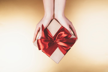 Woman's hands holding craft paper gift box