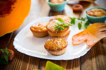 baked sweet pumpkin muffins with dried apricots inside,