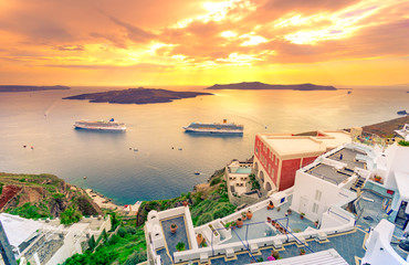 Amazing evening view of Fira, caldera, volcano of Santorini, Greece with cruise ships at sunset. Cloudy dramatic sky.