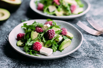 Salad with arugula, avocado, raspberries and brie cheese