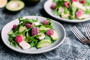 Salad with arugula, avocado, raspberries and brie cheese
