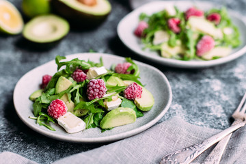 Salad with arugula, avocado, raspberries and brie cheese