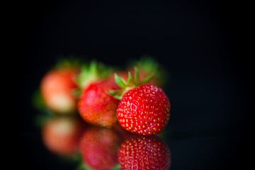 ripe red strawberries on a black background