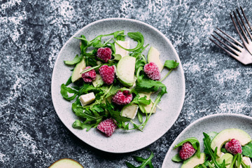 Obraz na płótnie Canvas Salad with arugula, avocado, raspberries and brie cheese