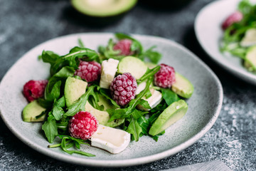 Salad with arugula, avocado, raspberries and brie cheese