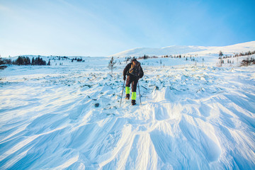 Tourist in the wild. Snow storm, despair. Lost his way. Ural winter landscape with giant frozen stone cliffs-buttes on a highland plateau.Russia in winter
