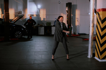 Naklejka na ściany i meble Good looking manager woman in a suit attractive look dancing in a garage after they finished the work day