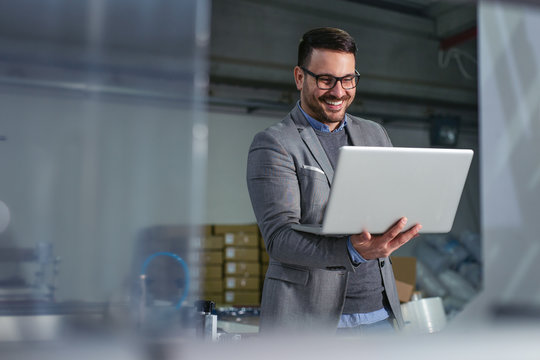 Engineer in the factory using laptop computer for maintenance.