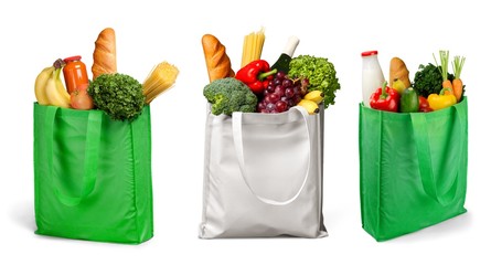 Bag full of groceries on wooden desk with pastel background