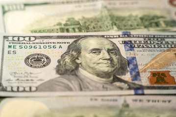 Obraz na płótnie Canvas 100 dollars bills close-up and portrait of Benjamin Franklin on US cash bill