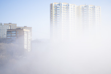 Morning fog among high buildings at residential district. Foggy urban scene