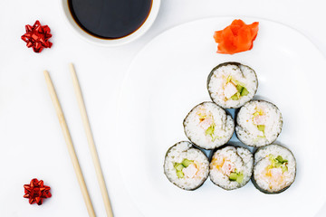Funny edible Christmas tree, from sushi rolls, on white background. Creative idea for japanese restaurant. The concept of food for the new year and christmas. Top view. Copy space.