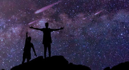two boys silhouette with enjoy Milky Way and beautiful night sky full of stars in background.