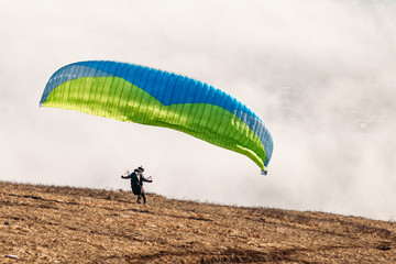 paraglider starting to paragliding above mountain