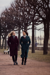 Two young woman walking in a windy day. Friendship.