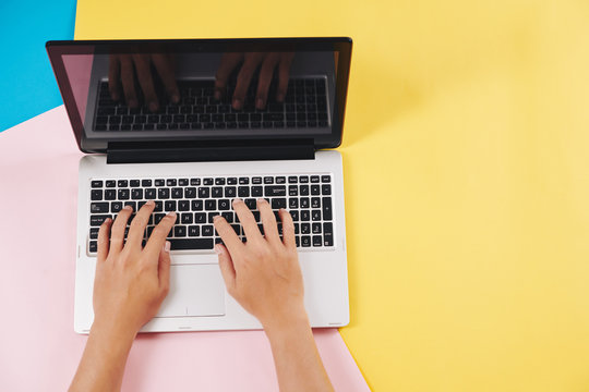 Hands Of Software Developer Working On Laptop At His Colorful Desk, View From Above