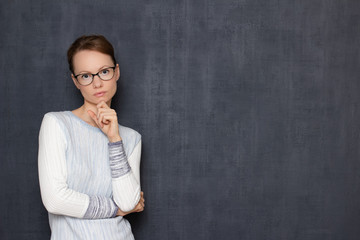 Portrait of serious focused girl with glasses listening interlocutor
