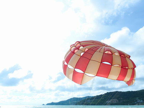 Opened parachute dome against the sky, for tourists' entertainment. copyspace