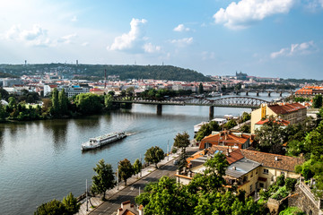 Fototapeta na wymiar Pleasure ships sail under a Railway bridge on the Vltava river in Prague.
