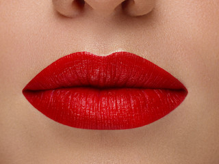 Cosmetics, makeup and trends. Bright lip gloss and lipstick on lips. Closeup of beautiful female...