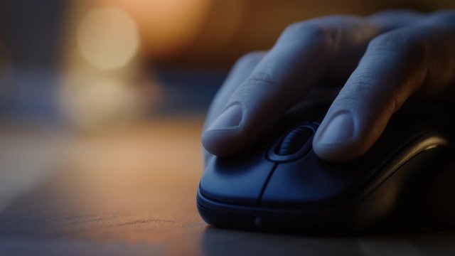 Close-up Macro Shot: Person's Hand Using Wireless Computer Mouse, Scrolls through Apps and Websites with a Wheel and Clicks on Buttons. In the Background Evening Light