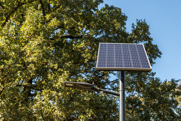 Modern new street LED light powered by solar panel with cells charging on the sun 