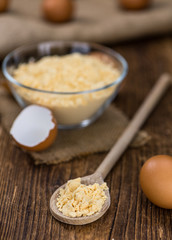 Old wooden table with fresh Powdered Eggs (close-up shot; selective focus)