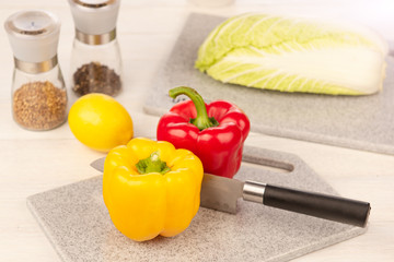 A section of bell pepper with a sharp knife on a cutting board made of artificial stone