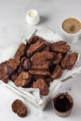 Traditional Italian homemade biscotti cookies or cantuccini with chocolate in a light grey wooden tray on a light background.