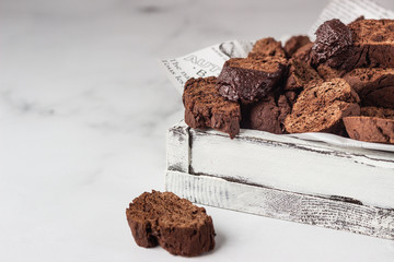 Traditional Italian homemade biscotti cookies or cantuccini with chocolate in a light grey wooden...