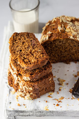 Butter-free and sugar-free banana bread with almond on a light grey wooden tray. Ideas and recipes for healthy diet breakfast. Selective focus.