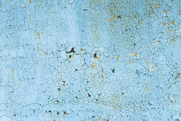 Peeling paint on rusty steel door. Corrosion on a metal surface. Abstract background, texture. Blue cracked painted wall.
